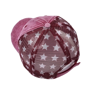 Close-up of wine red distressed mesh baseball cap with white star print and pony tail hole