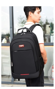 Man wearing a large capacity black business travel laptop backpack against glass building