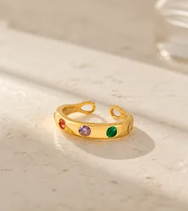 Gros plan d'une bague dorée ajustable sertie de pierres en zircone colorées