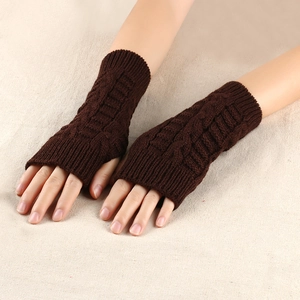 Detail of dark brown cable knit fingerless gloves showing rib knit cuffs on fabric