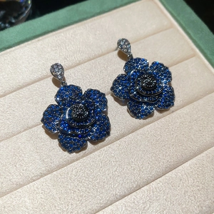 Macro detail of dark blue zircon flower earrings with multi-layered crystal petals
