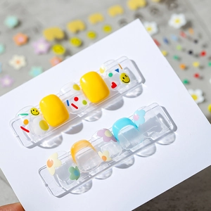 Stereo thin nail stickers with yellow smiles and blue floral patterns on a white card