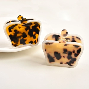 Detailed view of crown shaped acetate hair claws in amber and cream tortoiseshell patterns