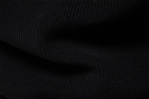 Macro view of black knit sweater fabric showing detailed texture and high-quality weave