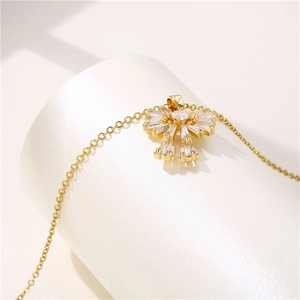 18k gold plated stainless steel bow necklace with clear zircon pendant on a display stand
