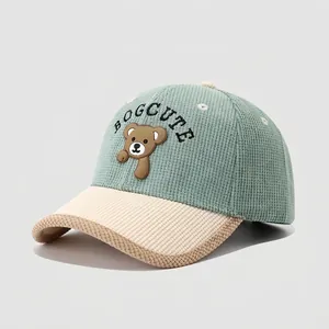 Detail of mint green and beige corduroy kids baseball cap with brown 3D bear patch