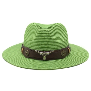 Detail of green straw cowboy hat featuring brown faux leather band and silver bull skull