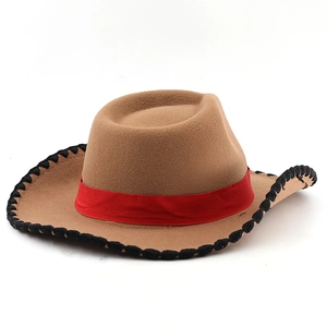 Detail of light brown cowboy hat with black braided edge and red decorative band