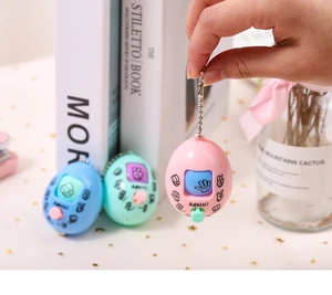 Macro detail of egg-shaped rock paper scissors game keychain with metal chain