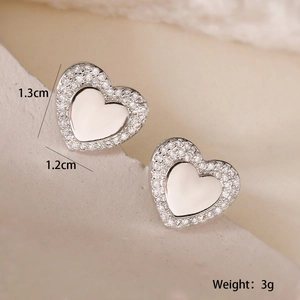 Macro detail of silver heart stud earrings with zircon inlay showing 1.3cm dimensions