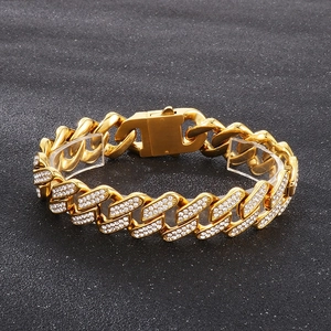 Vergoldetes Cuban Link Armband mit glitzernden Strasssteinen auf schwarzem Grund