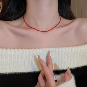 Close-up of minimalist red crystal beaded necklace worn on collarbone for a sleek look