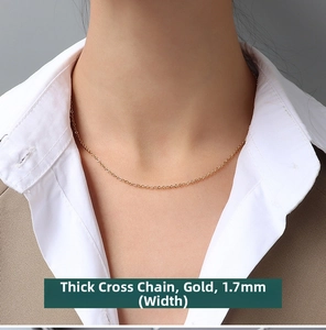 Detailed view of a 1.7mm thick golden cross chain necklace worn by a fashion model