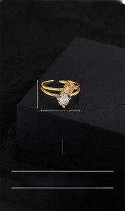 Macro detail of intertwined ring featuring pear-cut white and champagne oval zircons