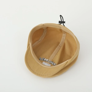 Internal detail of khaki kids beret featuring adjustable elastic drawstring and brand label