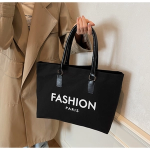Detail der schwarzen Canvas-Tragetasche mit Fashion Paris Aufdruck und PU-Griffen