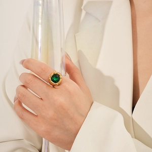 Dettaglio di anello vintage con zircone quadrato smeraldo su modella con fascia d'oro