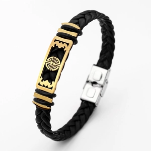 Macro shot of black braided leather bracelet featuring gold bat and fù character pendant