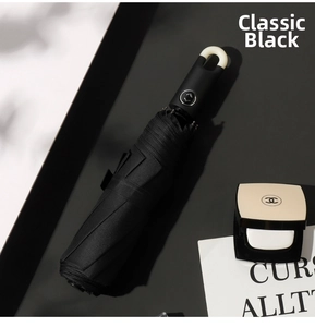 Close-up of classic black automatic umbrella with portable handle ring and silver button