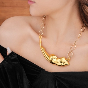 Gros plan du collier avec pendentif doré irrégulier sur vêtement en velours noir