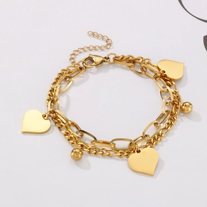 Close-up of double-layer gold titanium steel chain bracelet with heart pendants