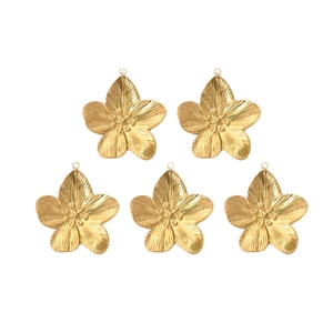 Five gold stainless steel flower charms with radial texture on a clean white background
