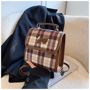 Detail view of vintage plaid backpack featuring dog embroidery and pink stripe accents