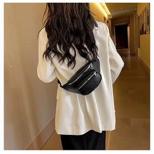 Mannequin portant un sac banane noir mat à double fermeture éclair dans un couloir