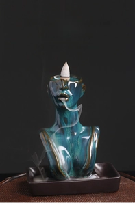 Macro detail of female bust backflow incense burner with teal glaze and flowing smoke
