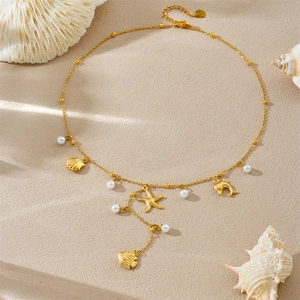 Golden Y-chain necklace with starfish dolphin shell and pearl on beach background