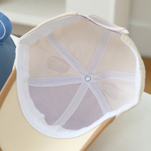 Close-up of the mesh lining and reinforced stitching inside the beige toddler baseball cap