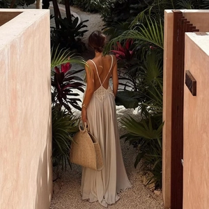 Detail of a backless beige halter maxi dress with lace inserts for a summer resort look