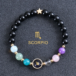 Detailed shot of Scorpio beaded bracelet with black stones and golden constellation charm
