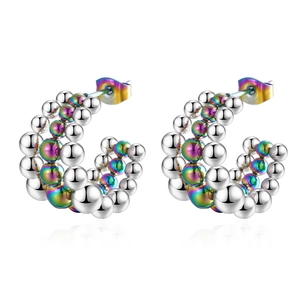 Macro view of C-shaped silver earrings with iridescent gradient metal beads and fringe detail