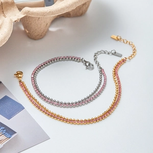 Détail de bracelets en acier doré 18K et argenté avec zircon rose et fermoir mousqueton robuste