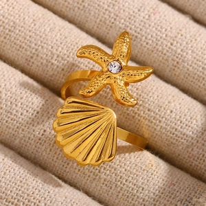 Macro shot of 18K gold plated starfish and shell open ring with cubic zirconia
