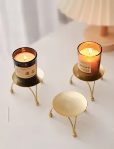 Close-up of a Nordic minimalist gold iron candle holder with ball feet for aromatherapy
