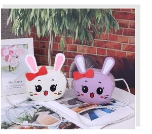 Detail of cute rabbit crossbody bags in white and lilac with soft 3D ears and bow