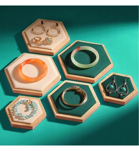 Detailed view of hexagonal bamboo jewelry trays with beige and dark green velvet inserts