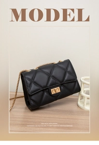 Close-up of black quilted PU leather shoulder bag with gold metal chain and twist lock