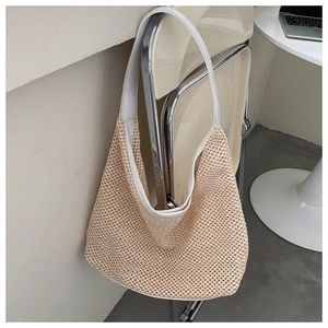 Detail of hollow woven shoulder bag featuring white leather edges and soft cream texture