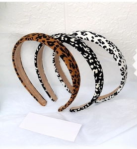 Detailed close-up of three leopard print sponge headbands in brown, grey and white colors