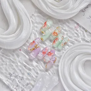 Macro shot of koi fish nail art stickers with gold accents and 3D pearls