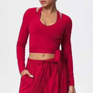 Close-up of deep red yoga top featuring criss-cross wrap design and adjustable waist ties