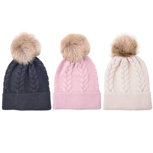 Three cable knit beanies in navy, pink, and white with detachable faux fur pom-poms