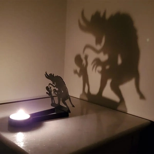 Macro view of metal candle holder projecting a Krampus shadow on the wall