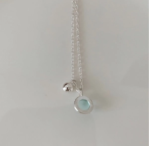 Detailed view of 925 sterling silver necklace with light blue crystal circular pendant