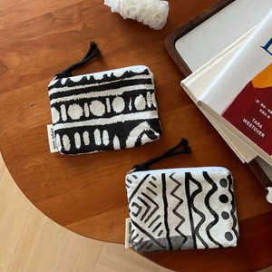 Detail of bohemian mini coin purse with geometric patterns and a black tassel charm