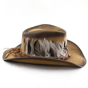 Detail of woven straw cowboy hat with feathers, vintage gradient finish and tassel rope
