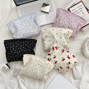 Détail de pochettes en toile seersucker à fleurs avec fermeture éclair et divers motifs